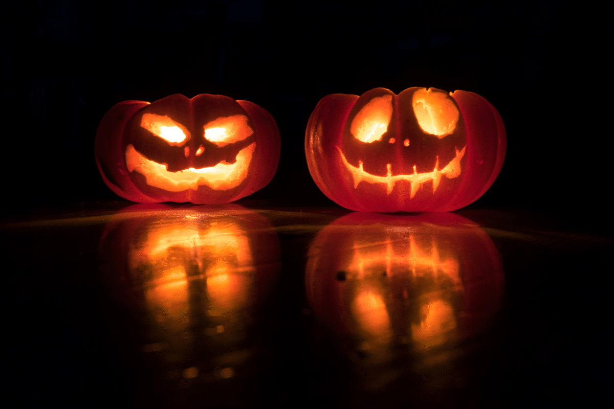 Two pumpkins glowing in the dark.