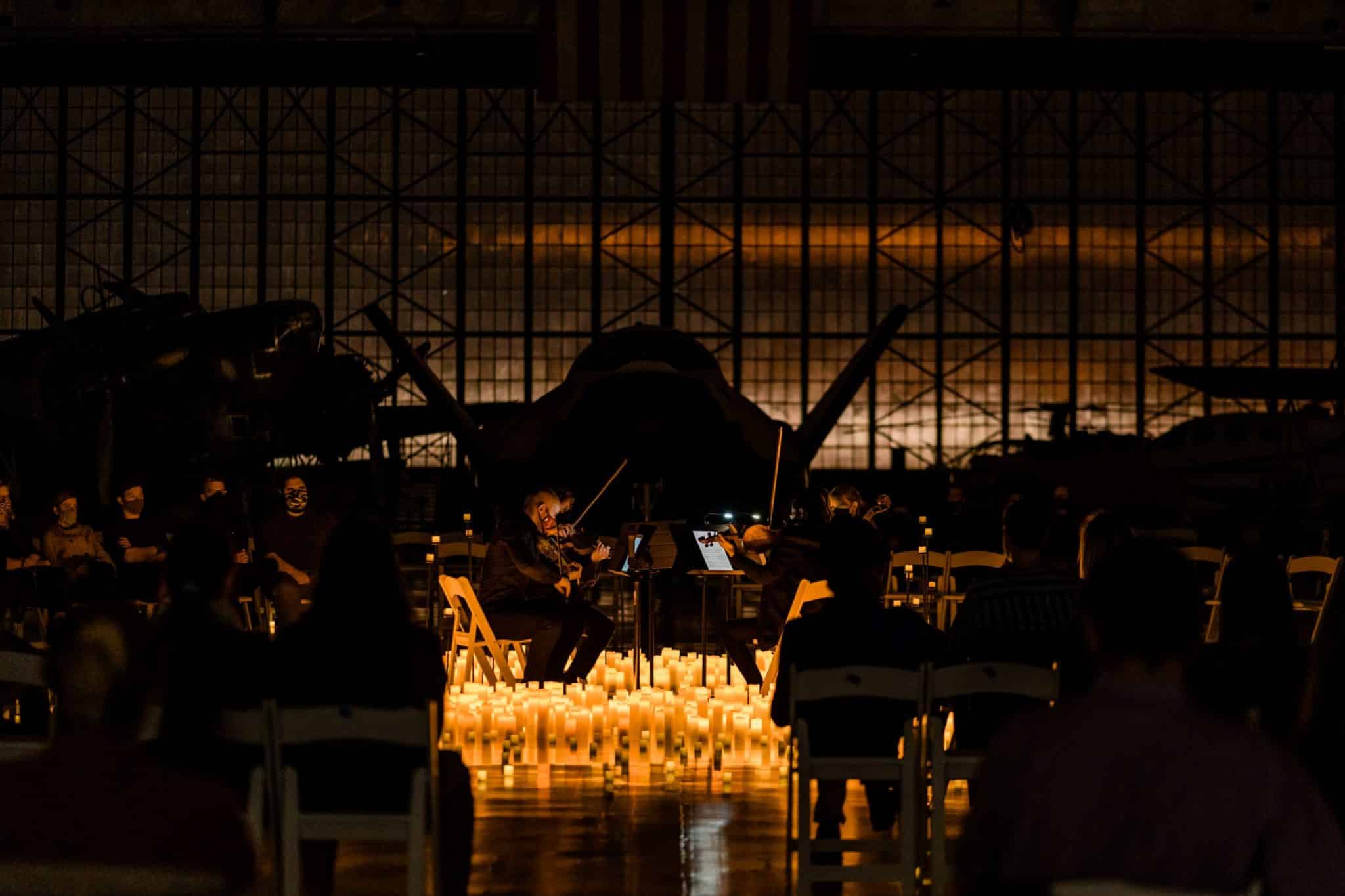 A string quartet performing at a Candlelight concert surrounded by candles.