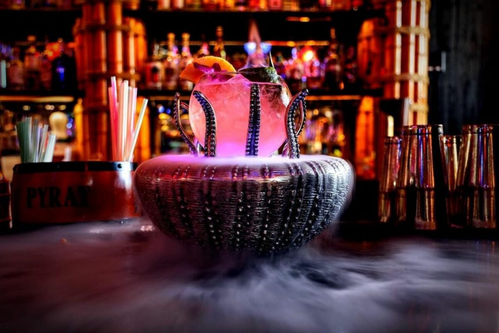 A black punch bowl covered in fog with tentacles and a pink light coming from the top.