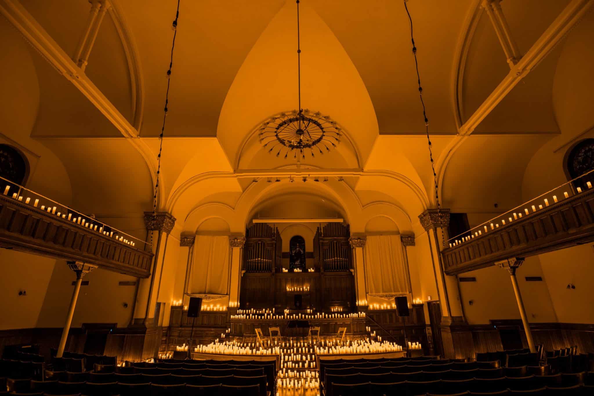 Inside of a church space with a stage set up for a Candlelight performance.