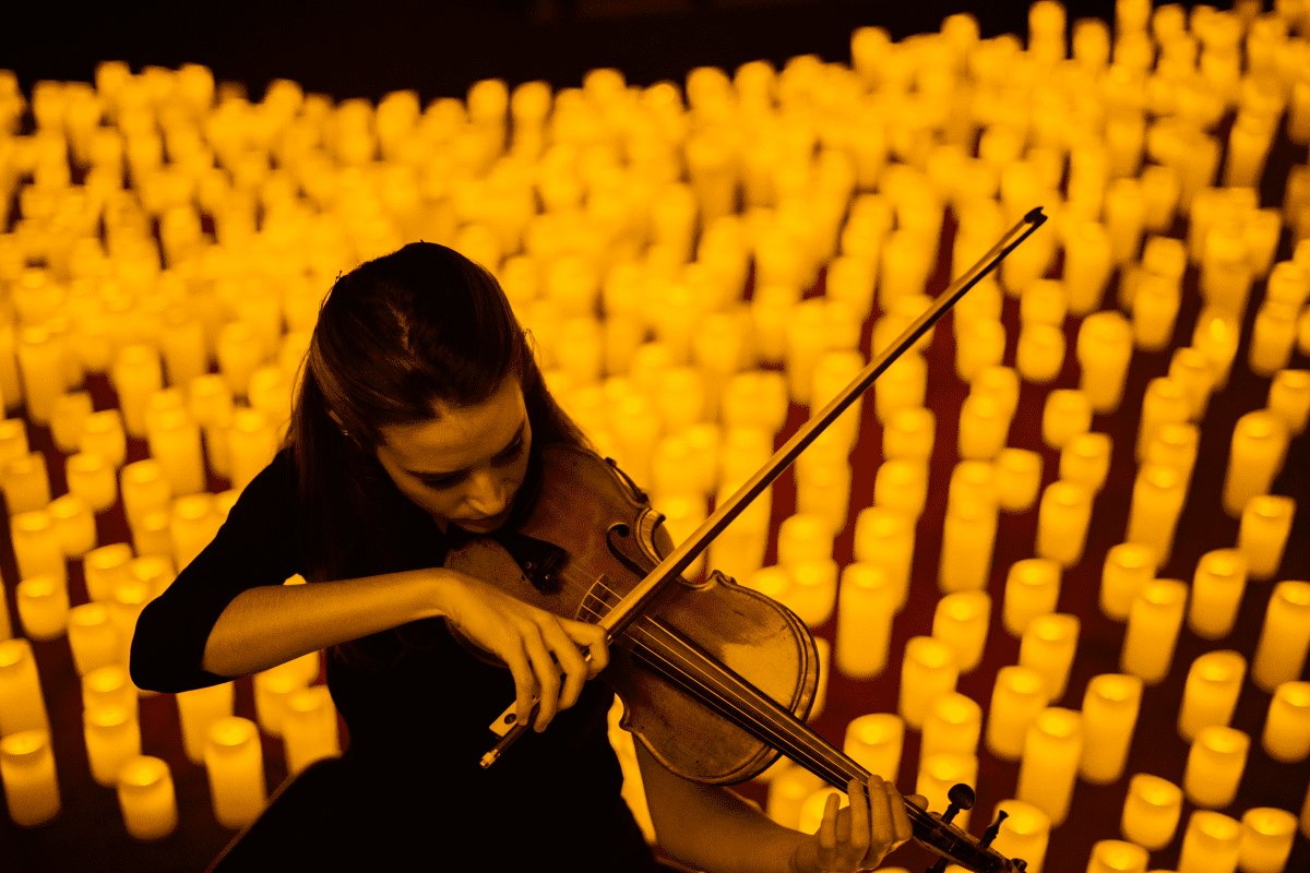 A woman playing the violin at a Candlelight concert.