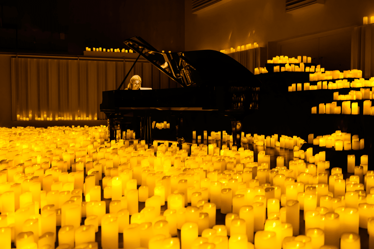 A woman playing the piano at a Candlelight concert.